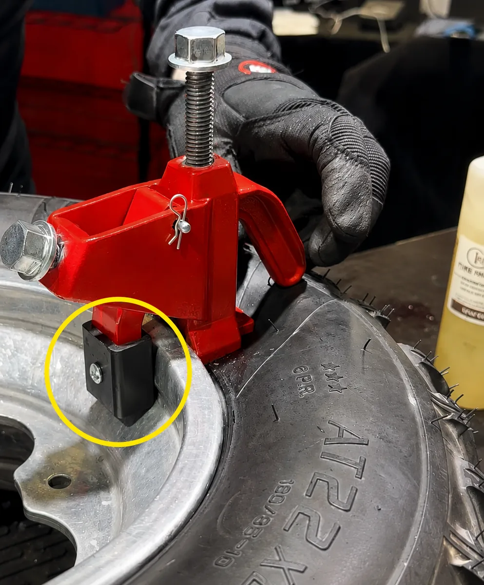 BeadBuster XB-450i and XB-550i HD clamped to a rim lip with protective pad, showing bead-breaking action