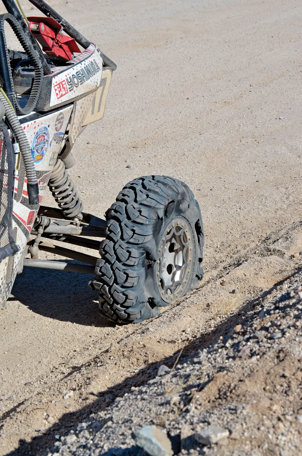 Damaged UTV tire on a dirt track showing the kind of flat that strands you far from the trailer